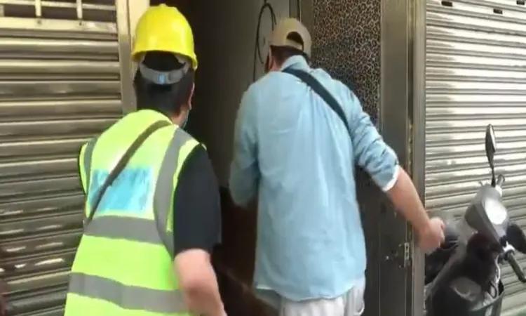 警方喬裝工程人員靠近破門。讀者提供