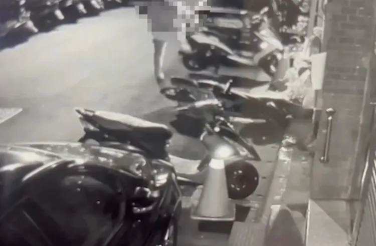 周男出腳踹倒停在路邊的機車。翻攝畫面