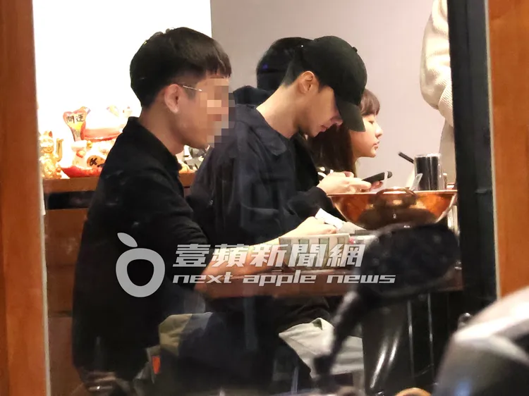 約會期間，壓低帽子的施柏宇（右），不時低頭滑手機。特勤中心攝