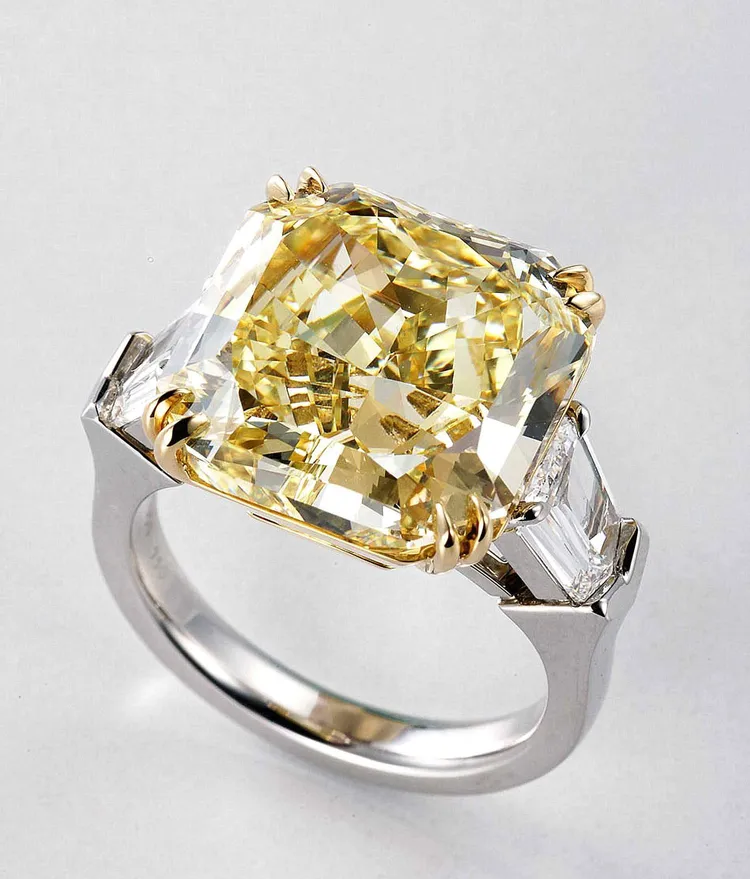 以15.01克拉雷德恩式切割黃鑽為主角的鉑金戒指，兩邊並鑲襯祖母綠形切割白鑽共1.86克拉，綻放耀眼黃金光彩，3737萬5000元。品牌提供