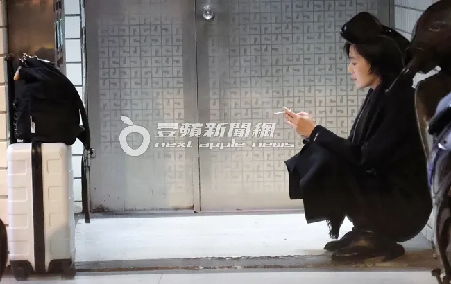 安溥在家門前，靠著牆壁抽菸。特勤中心攝