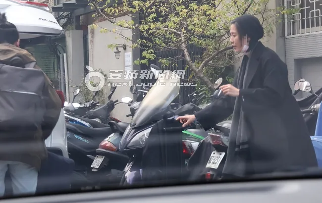 安溥（右）戴著毛帽叼著菸，和「辮子男」搬行李上計程車。特勤中心攝