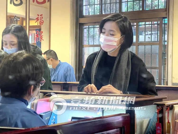 安溥（右）擲筊確認後，到服務中心解籤詩。特勤中心攝