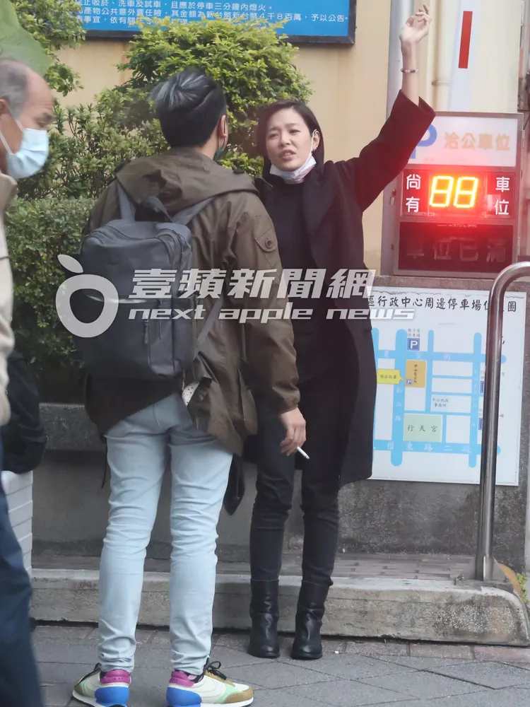 安溥（右）高舉左手，舒展肩頸疼痛，邊跟「辮子男」一起哈菸。《壹蘋》提醒您吸菸有礙健康。特勤中心攝