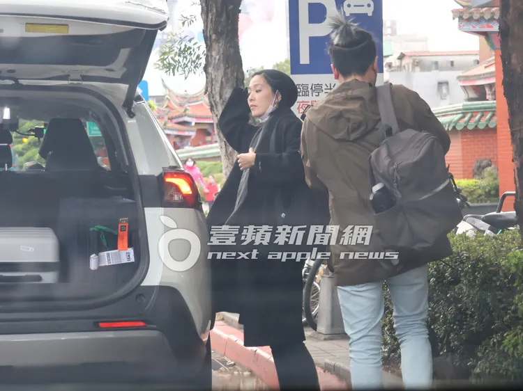 安溥（左）與「辮子男」搭車來到行天宮下車，在車旁脫下毛帽照鏡子。特勤中心攝