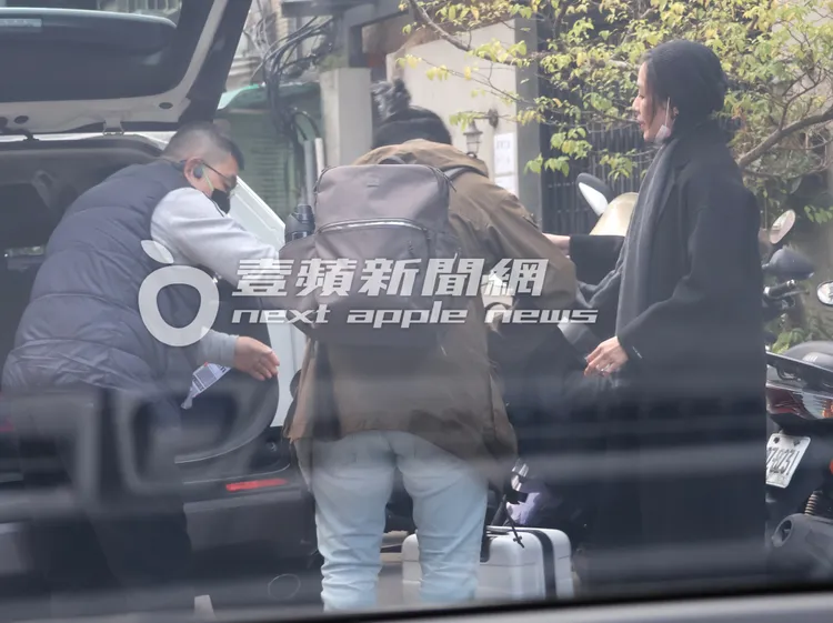 安溥（右）指揮「辮子男」幫忙搬行李上計程車。特勤中心攝