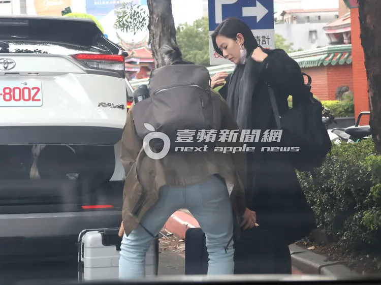 安溥（右）將毛帽脫下，辮子男貼心幫她搬行李，一起去行天宮拜拜。特勤中心攝