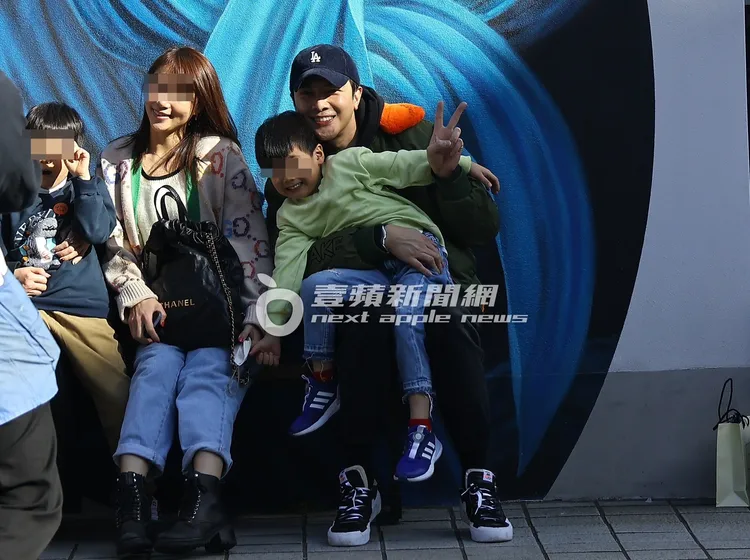 謝佳見（右）抱著友人小孩比出勝利手勢合照。特勤中心攝