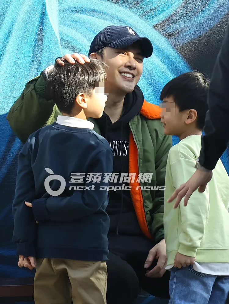 謝佳見（中）開心摸著小孩的頭。特勤中心攝
