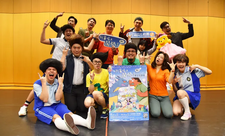 《阿甯咕又闖禍了YA～》加演場整排大合照，眾人比出劇中的搖滾手勢。周孝安（後排左起）、吳定謙、于善祿、阿布、阿布女兒薰薰、導演高天恒，前排左起為演員何海翔、林煒盛、尹仲敏、李培松、嘎造．伊漾、陳敬萱、黃琨婷。夢田影像提供