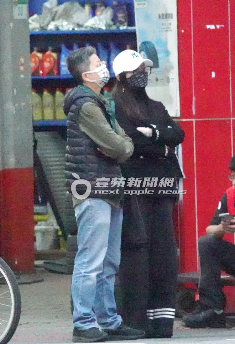 陳美鳳（右）與助理雙手交叉站在路邊等紅綠燈。特勤中心攝