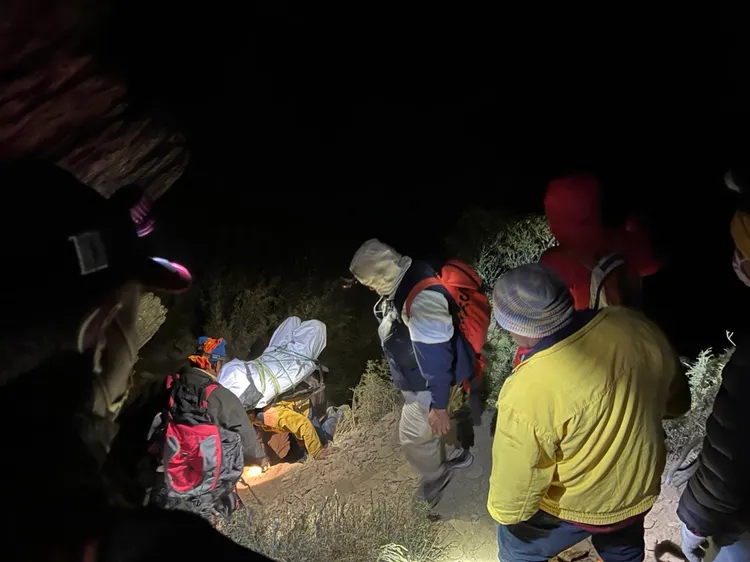 搜救人員輪流將孫男遺體揹負下山。民眾提供