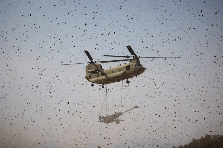 美國陸軍CH-47契努克直升機，吊掛一門M777榴彈砲。路透社