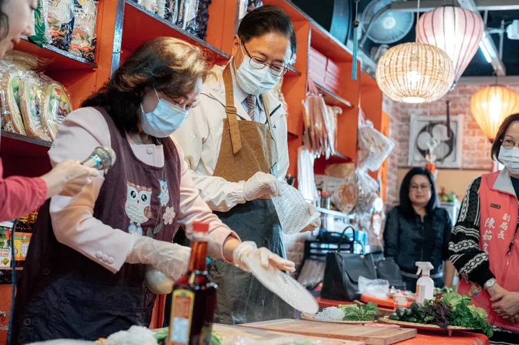 張善政和新住民體驗手做春捲。桃園市府提供