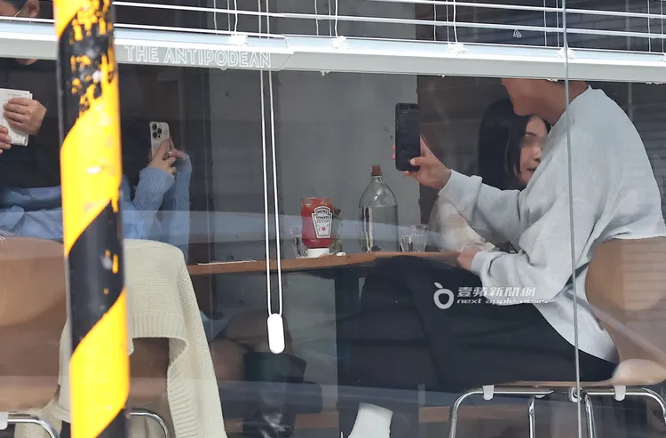 蔡凡熙（右）與陳華點好餐後，熟稔地拿起手機互相拍照。特勤中心攝