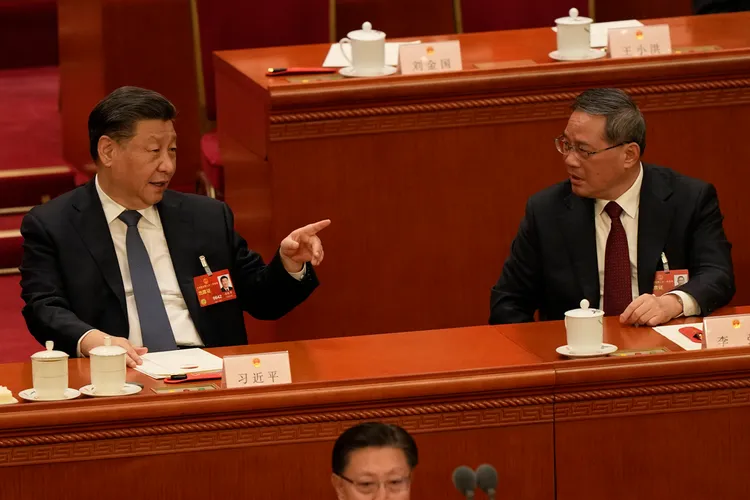 習近平與李強在11日會上交談。美聯社