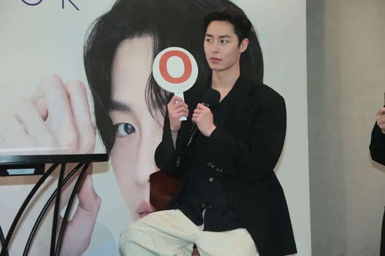 李宰旭記者會上舉牌玩快問快答。彭欣偉攝