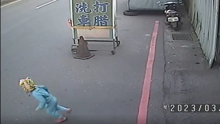 幼童一人獨自在馬路邊玩，突然往畫面左邊大馬路衝出去。翻攝自爆料公社