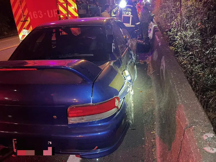 肇事自小客因過彎打滑，將對向男騎士撞落邊坡。讀者提供