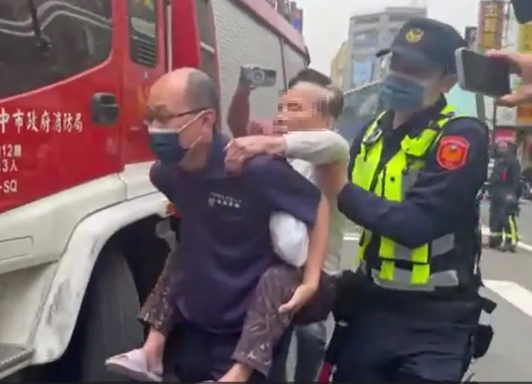 吳姓工人的阿嬤由警消合力揹負，委請對面公司員工照護。讀者提供