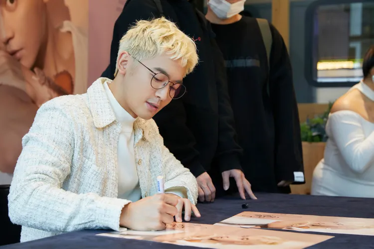 小樂為粉絲簽名。