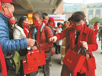王鳳(右)給過年回家的員工發放禮品。翻攝自《寧波網》