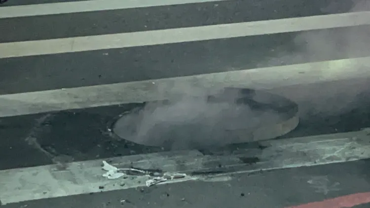 高雄市前金區成功一路、光復二街口人孔蓋，今晚冒出白煙。讀者提供