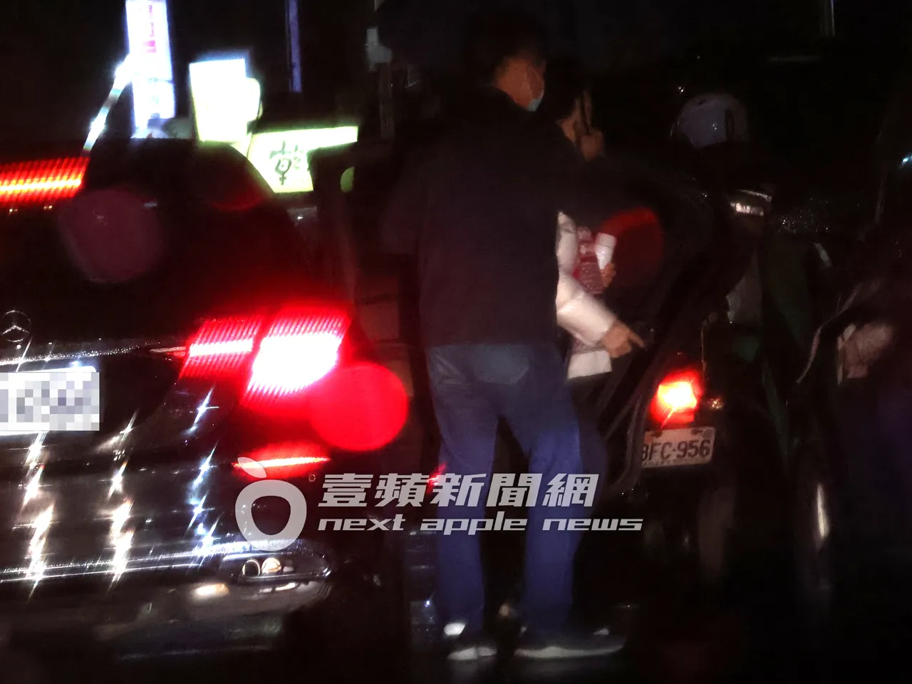 連奶奶(右)看完皮膚科返家,手拿水壺及iPhone 14 Pro,隨扈一路攙扶下車。特勤中心攝