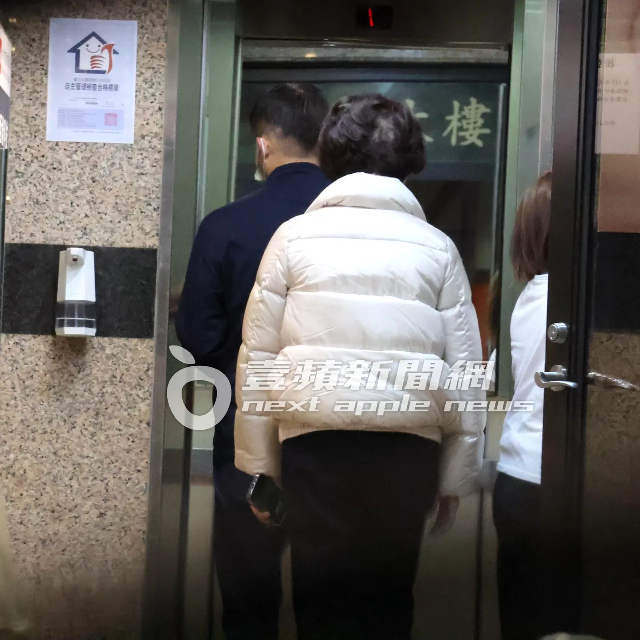 連奶奶(右)的背影走進電梯,搭上3樓的蔡仁雨皮膚科看醫生。特勤中心攝
