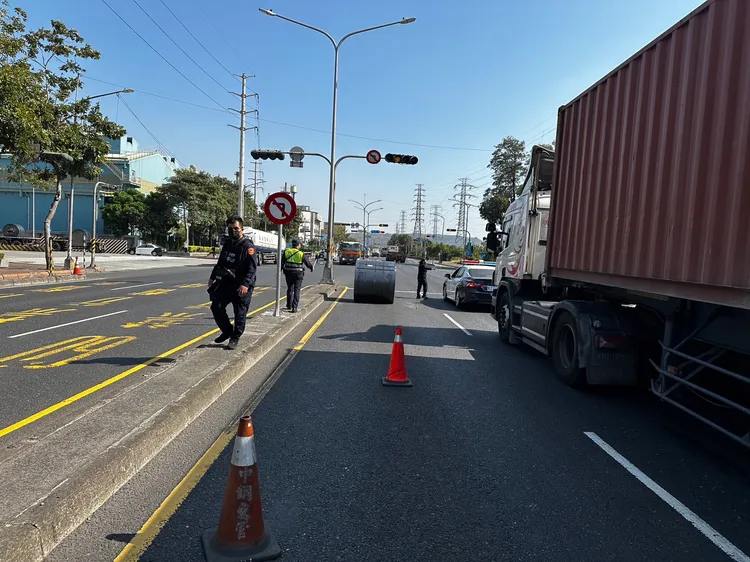 警方到場排除滑落到車道上的鋼捲。讀者提供