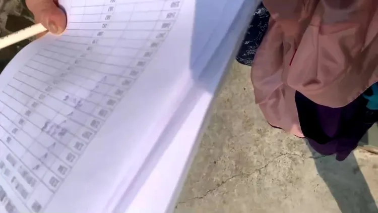 「全民監票行動聯盟」人員持名冊，在投開票所外紀錄投票人的特徵。民進黨提供