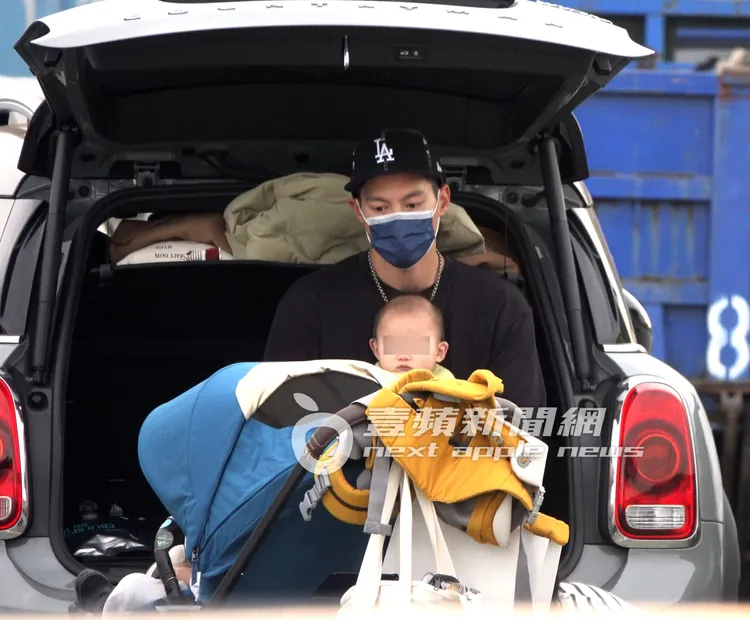許孟哲抱著兒子Liam坐在後車廂休息。特勤中心攝