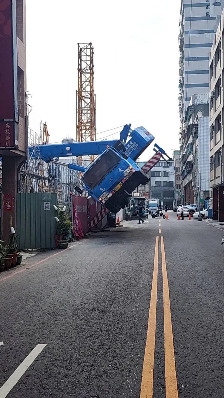 高雄小港一處工地因卡車上的吊臂吊掛太重的建材，吊臂整個倒塌，卡車跟著懸空。讀者提供