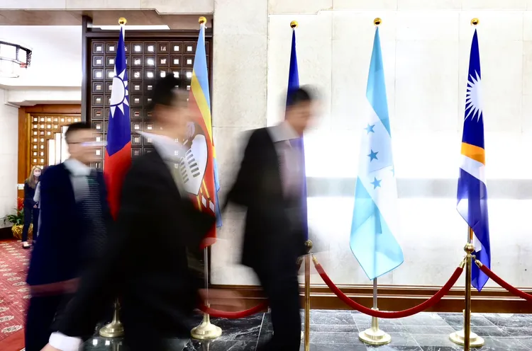 宏都拉斯總統卡斯楚打算轉跟中國建交，外交部官員一早忙碌穿梭總部，倘若確定斷交，宏國國旗（右2）屆時將會撤走。林林攝