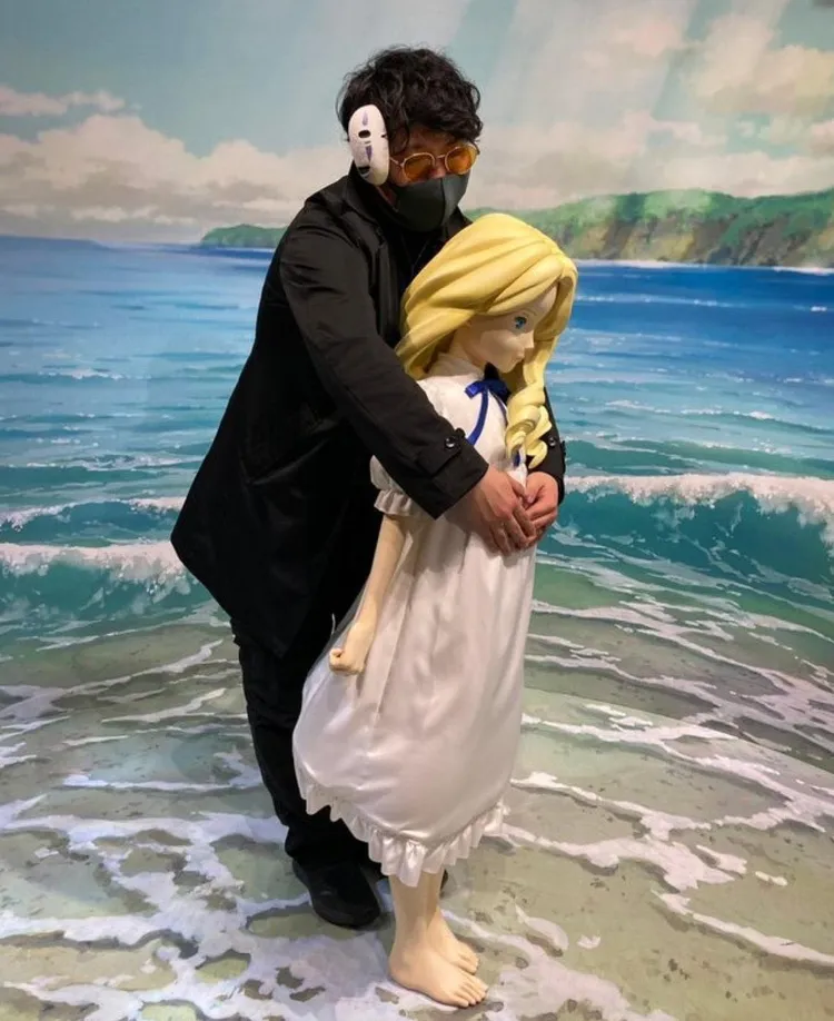 男性遊客從背後環抱少女雕像。翻攝推特