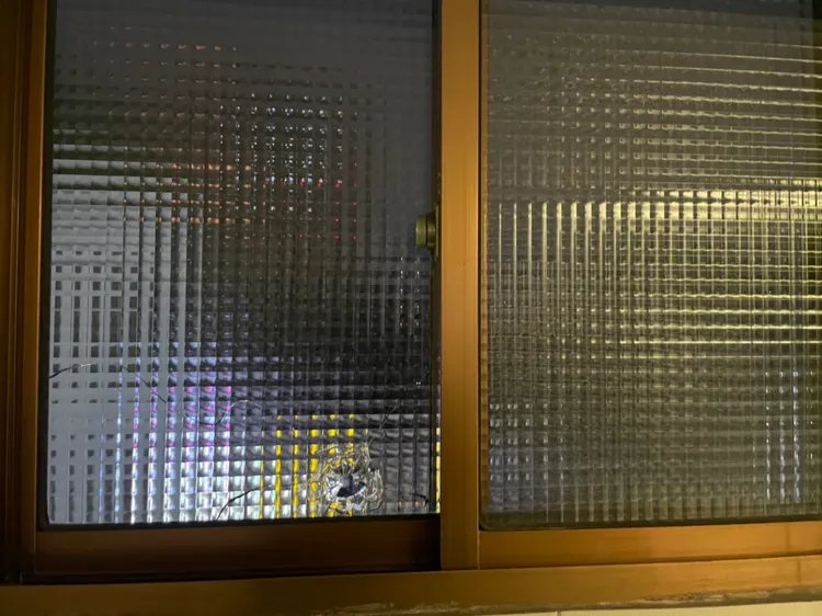 民宅玻璃遭射破出現明顯彈孔。蘆洲警分局提供