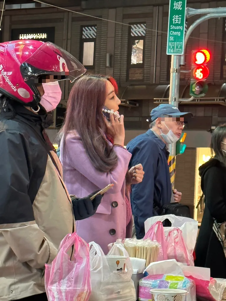 李宓（中）講電話等晚餐。蔡依庭攝