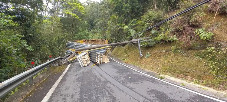 坪林區106乙線貨車翻覆浪板掉落，路邊電線桿也遭撞斷，交通受阻。警方提供