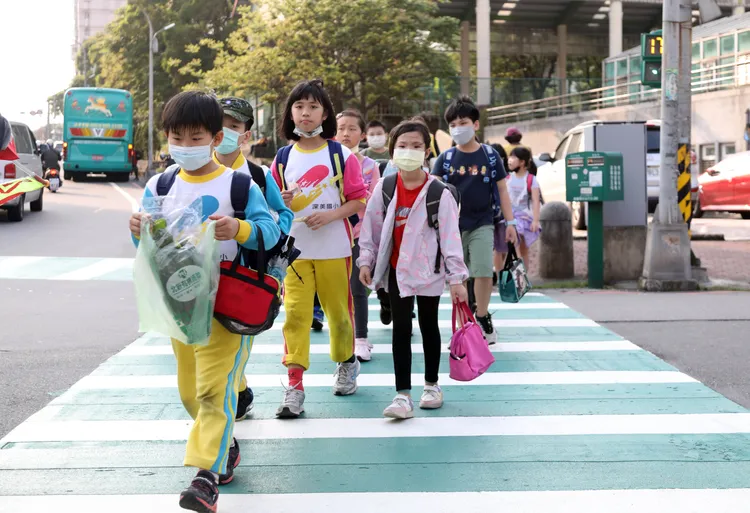 小朋友們走在顏色鮮豔的綠色斑馬線上，駕駛可更加清楚看見行人，提早減速，以免發生事故。鄭孟晃攝