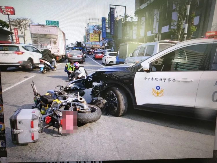 大型重機卡在警車下方。民眾提供