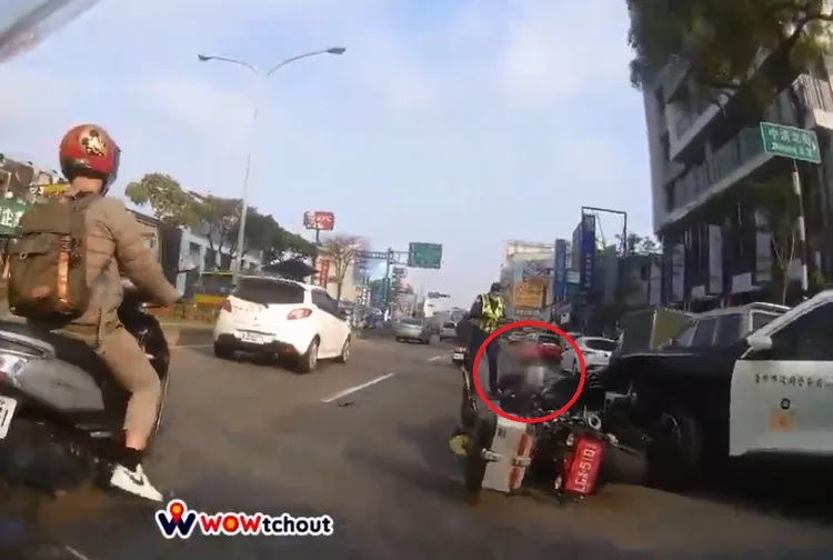 重機女騎士被撞翻落地，坐在警員旁邊痛到不斷哀號。翻攝臉書《Wowtchout -地圖型行車紀錄器分享平台》