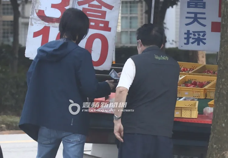 田馥甄的助理將一張千元大鈔遞給攤販。特勤中心攝