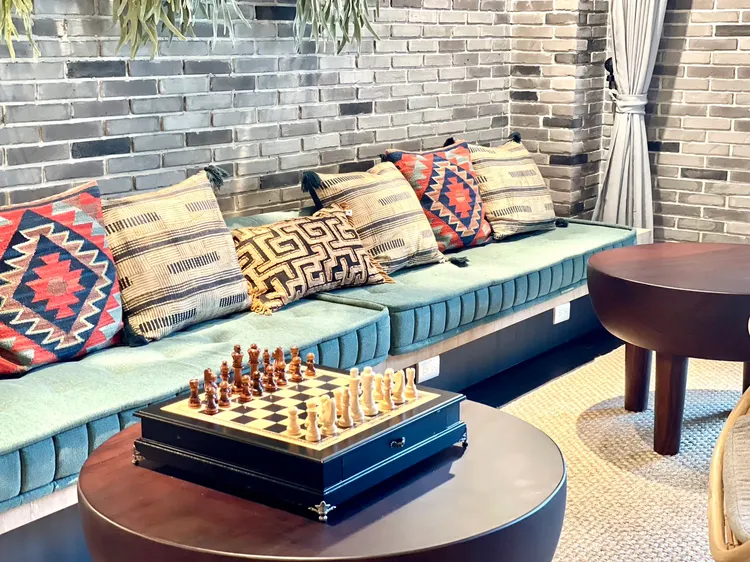 悅沐館採用大量木質設計結合南島石屋元素，旅客可在交誼區與親友下棋、聊天。曾仲葳攝