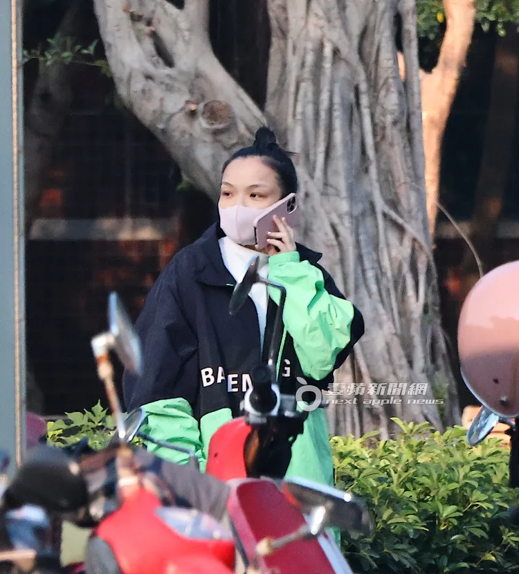 徐佳瑩拿著iPhone 14 Pro Max在民權公園散步、講電話，身上穿著要價近7萬元、巴黎世家外套。特勤中心攝