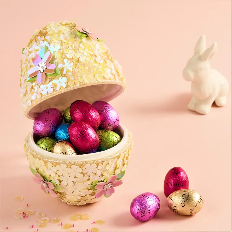 佈滿精緻花朵裝飾的復活蛋呈現春日的靈動氣息，一片片手工縫製的亮片折射出迷人光彩，搭配迷你復活蛋巧克力，傳遞屬於復活節的美好祈願，春季復活蛋形巧克力禮盒15顆裝售價3290元。業者提供