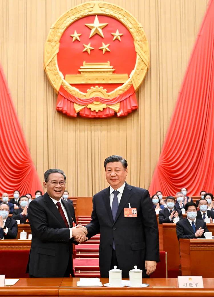 習近平（右）與李強握手。新華社