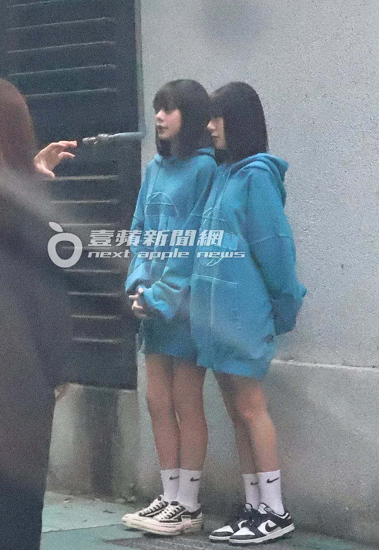 軒姐宸妹並肩站在牆前，供攝影拍照。特勤中心攝