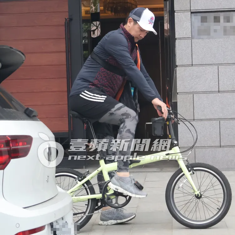 伊正目送女兒上樓後，準備移腳踏車停放。特勤中心攝