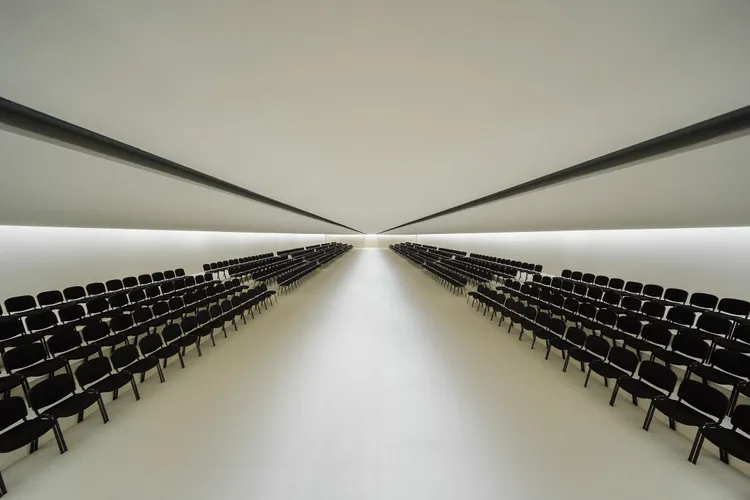 BALENCIAGA秀場以低調素白到極致的「回歸純粹」樣貌登場，僅有觀眾席的黑椅排列著。品牌提供