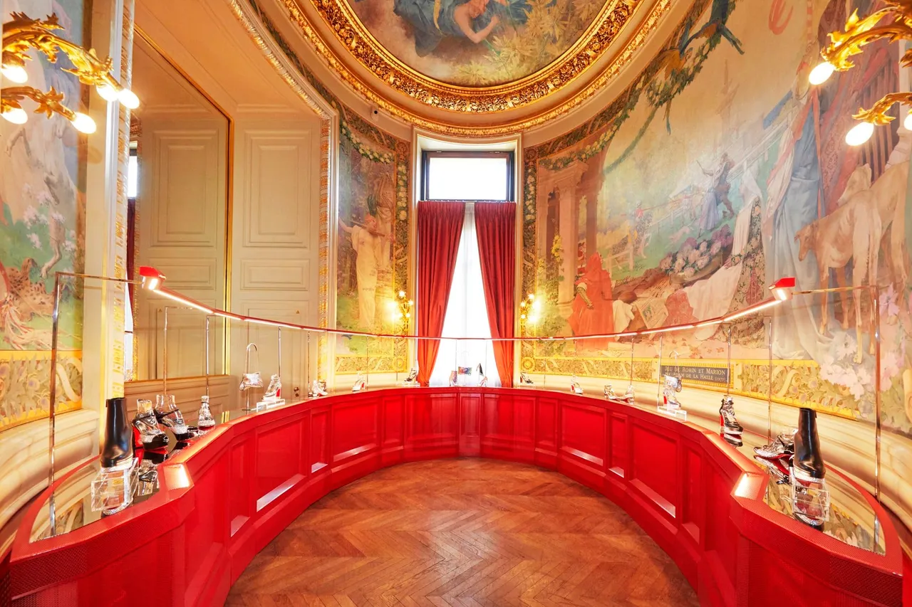 喜歌劇院的大宴會廳中,以2個金屬紅色塔形展台和2個圓形壁龕展列著Christian Louboutin 2023年秋冬系列鞋款與包款,帶來精彩的Loubishow。品牌提供